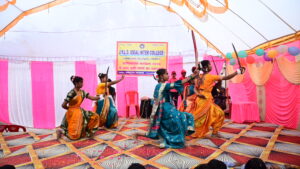 JYLD Ideal Inter College varshikotsav 2026 mein chhtrayen orange aur teal saree mein talwar lekar veer ras dance prastuti dete hue manch par