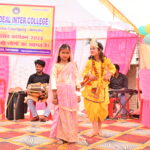 JYLD Ideal Inter College varshikotsav 2026 mein chhoti bachchiyan Radha Krishna ke vesh mein manch par natak prastuti dete hue dhol tabla sangat ke saath