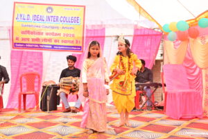 JYLD Ideal Inter College varshikotsav 2026 mein chhoti bachchiyan Radha Krishna ke vesh mein manch par natak prastuti dete hue dhol tabla sangat ke saath