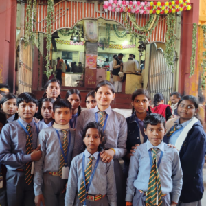 JYLD Ideal Inter College ke vidyarthi aur shikshika school uniform mein mandir dharmik sthal par educational tour ke dauran